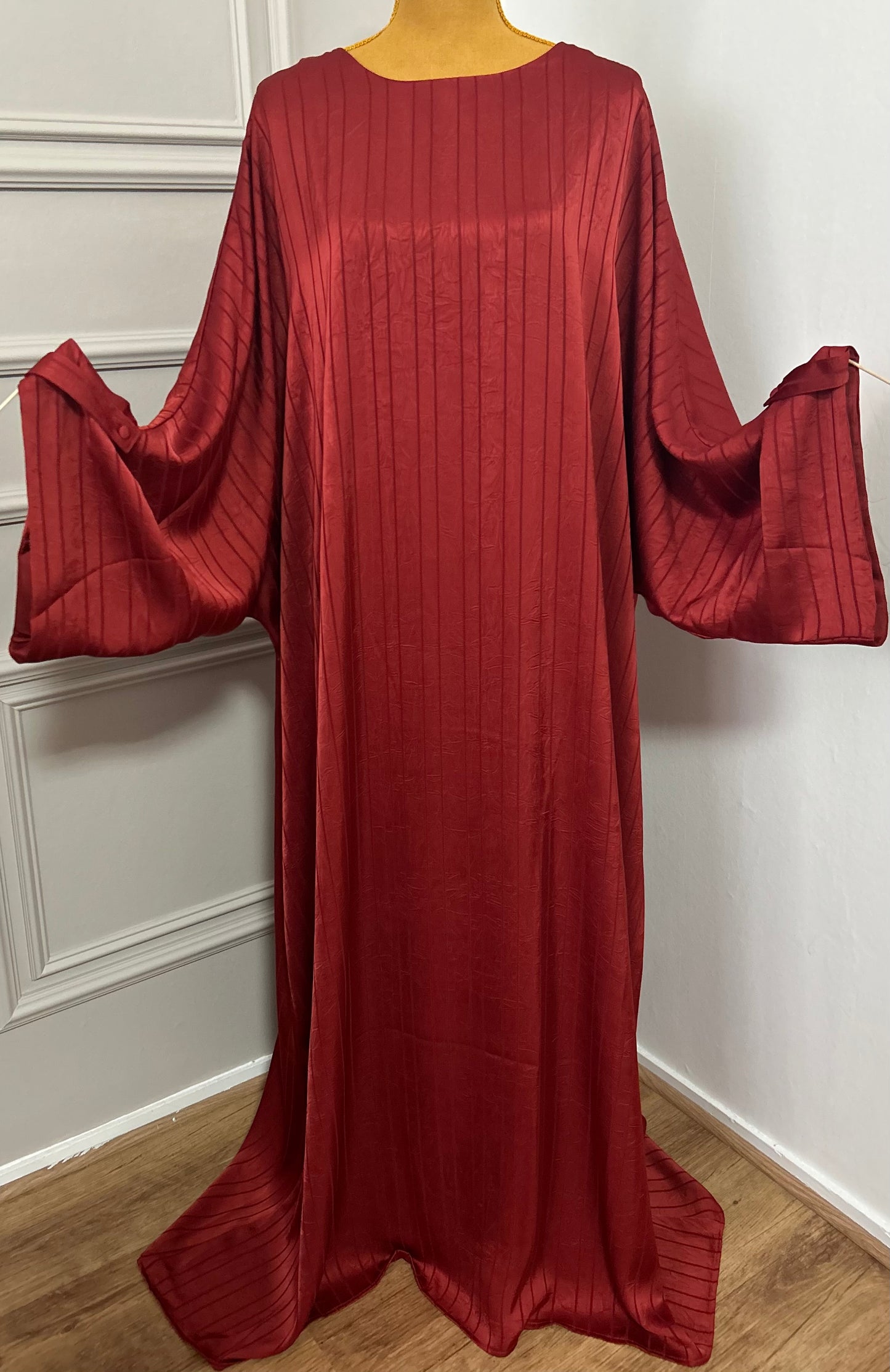 Abaya satinée bordeau pour femme, coupe longue et fluide, tissu texturé, manches longues, col rond.