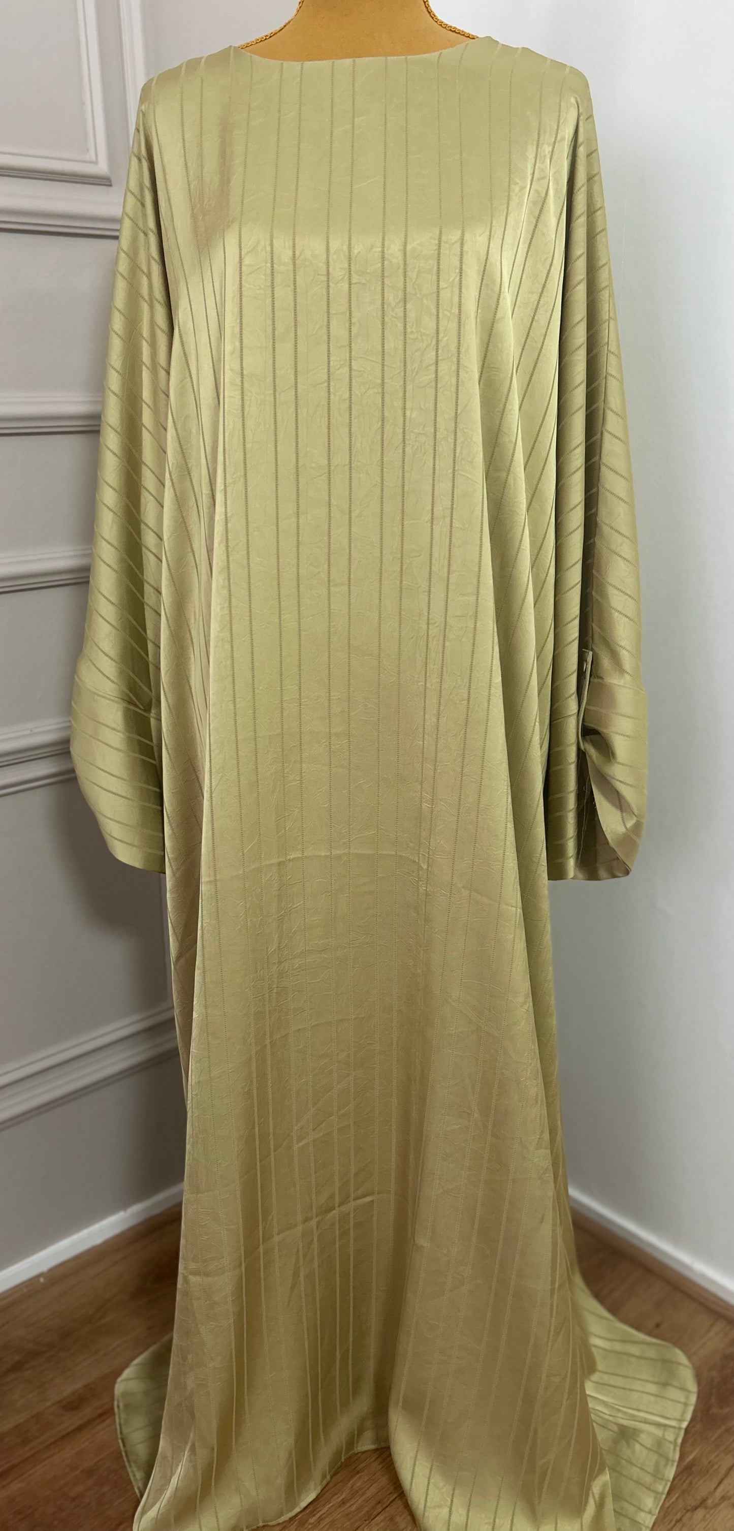 Abaya satinée vert anis pour femme, coupe longue et fluide, tissu texturé, manches longues, col rond.