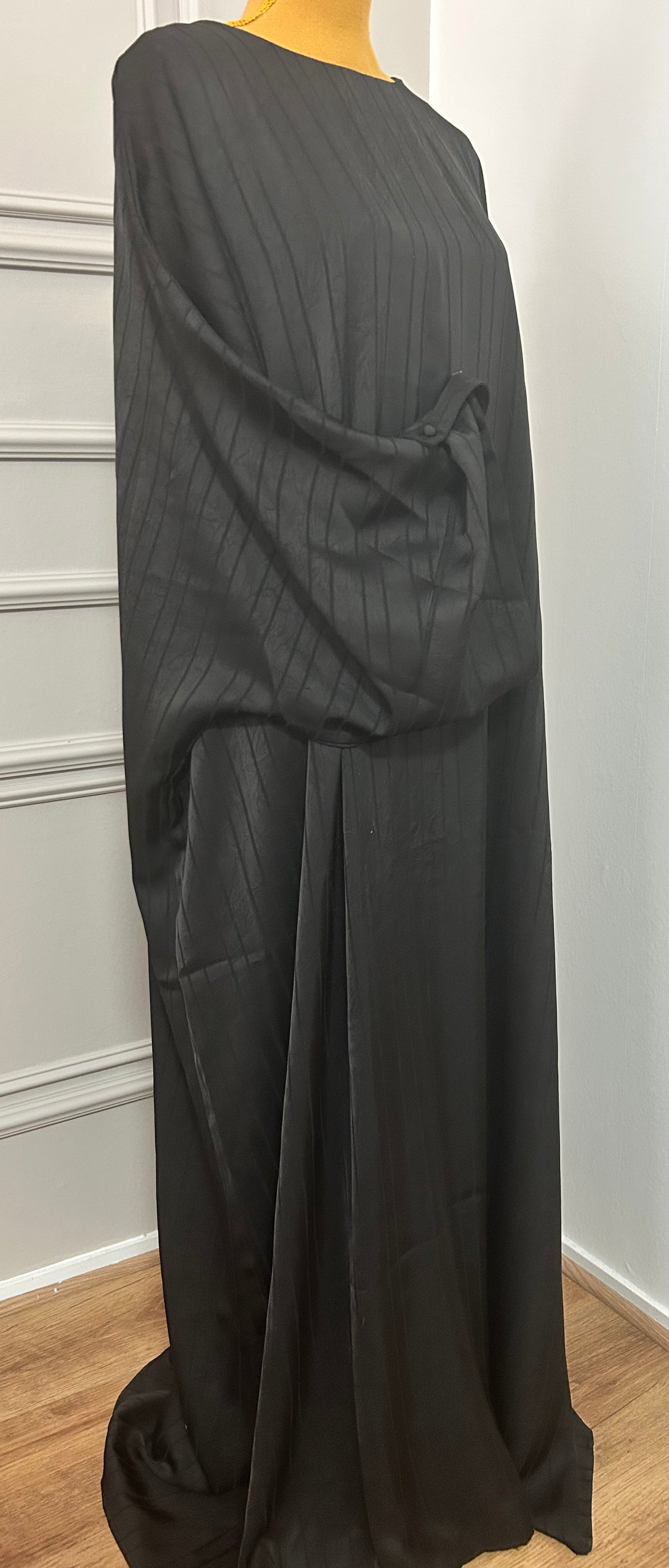 Abaya satinée noir pour femme, coupe longue et fluide, tissu texturé, manches longues, col rond.