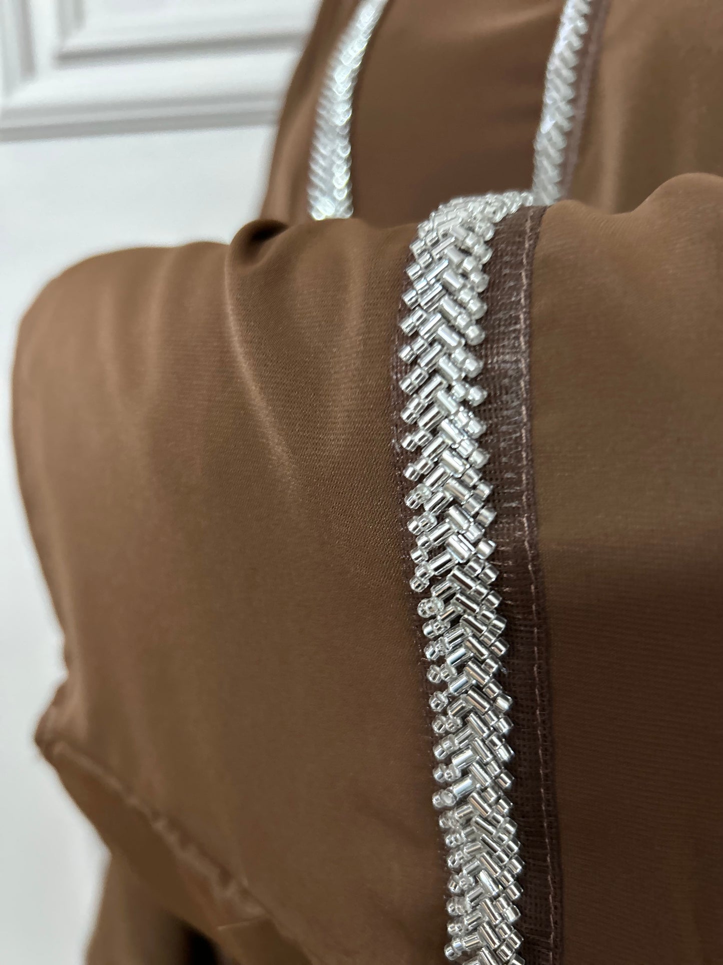 Craquez pour cette abaya marron 2 pièces alliant confort et élégance, avec son kimono orné de strass et sa sous-robe fluide. Idéale pour les occasions ou un style raffiné au quotidien.