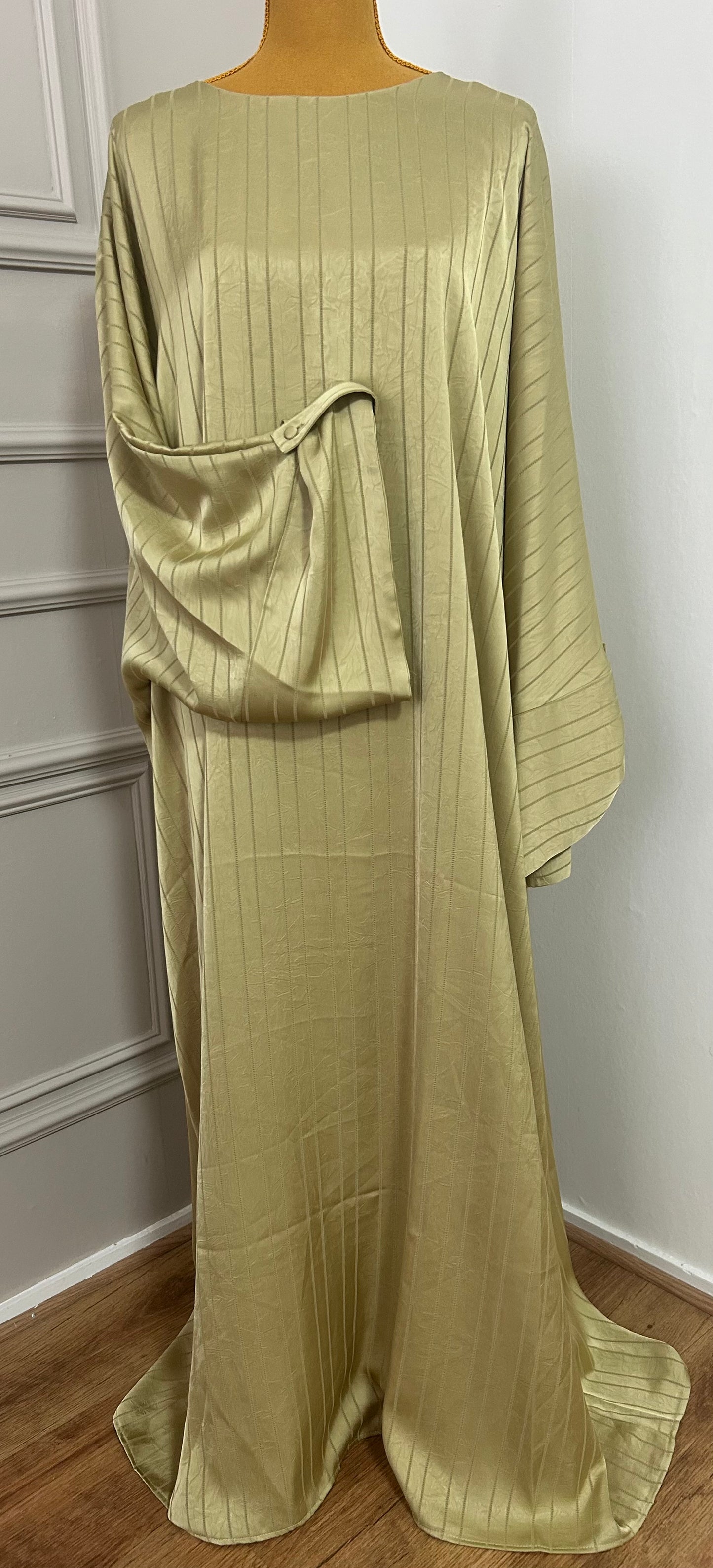 Abaya satinée verte pour femme, coupe longue et fluide, tissu texturé, manches longues, col rond.