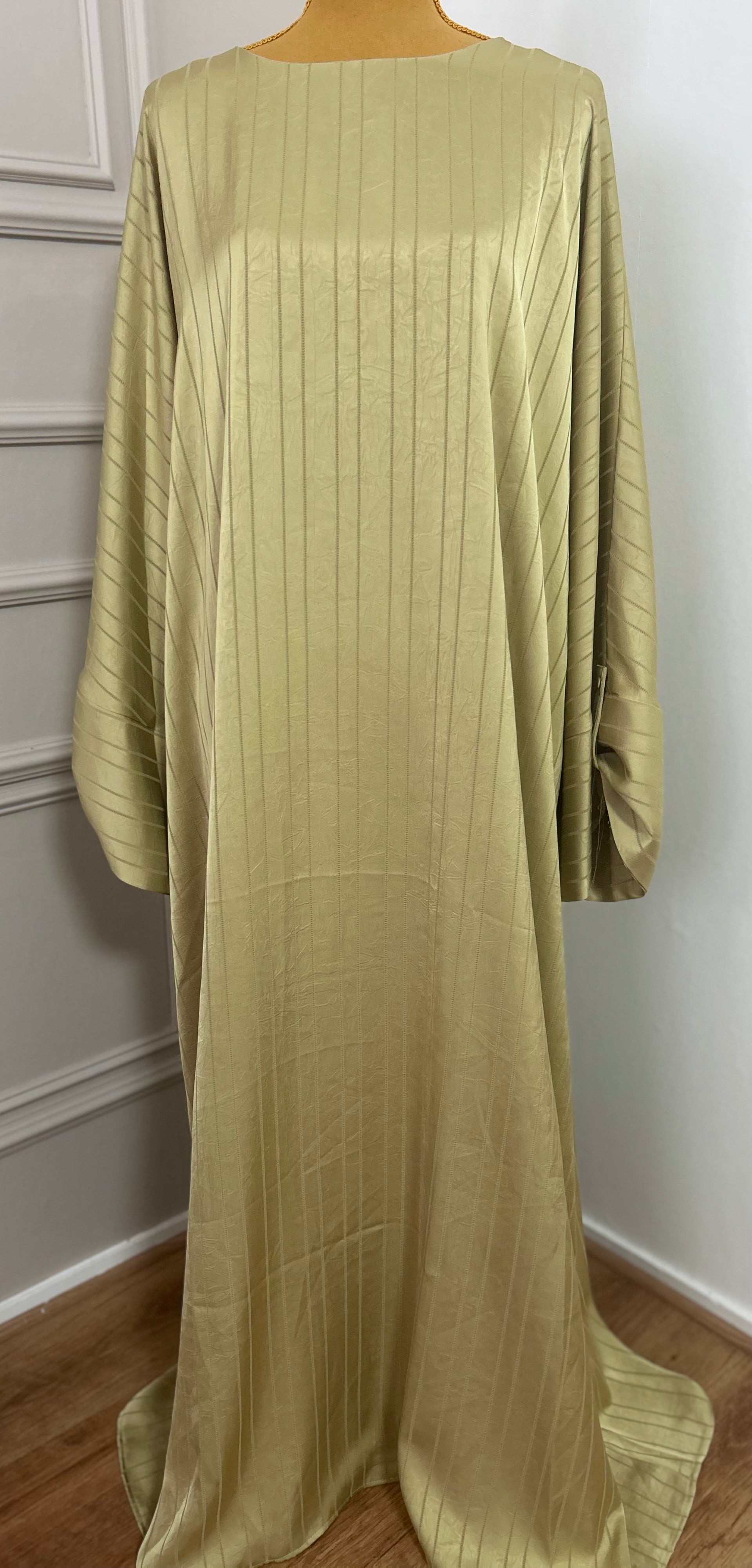 Abaya satinée vert anis pour femme, coupe longue et fluide, tissu texturé, manches longues, col rond.