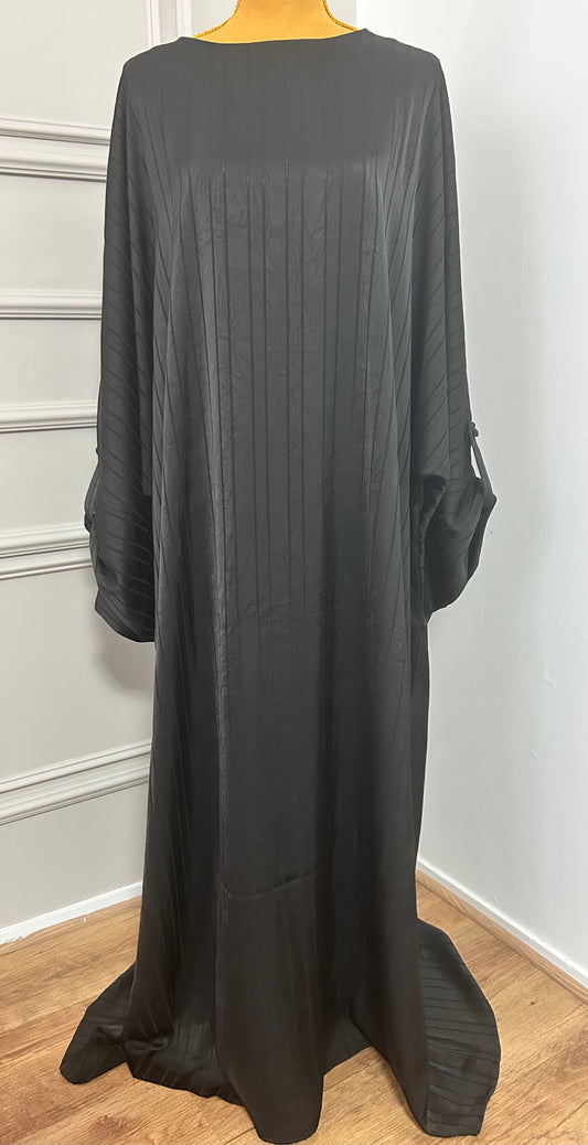 Abaya satinée noire pour femme, coupe longue et fluide, tissu texturé, manches longues, col rond.