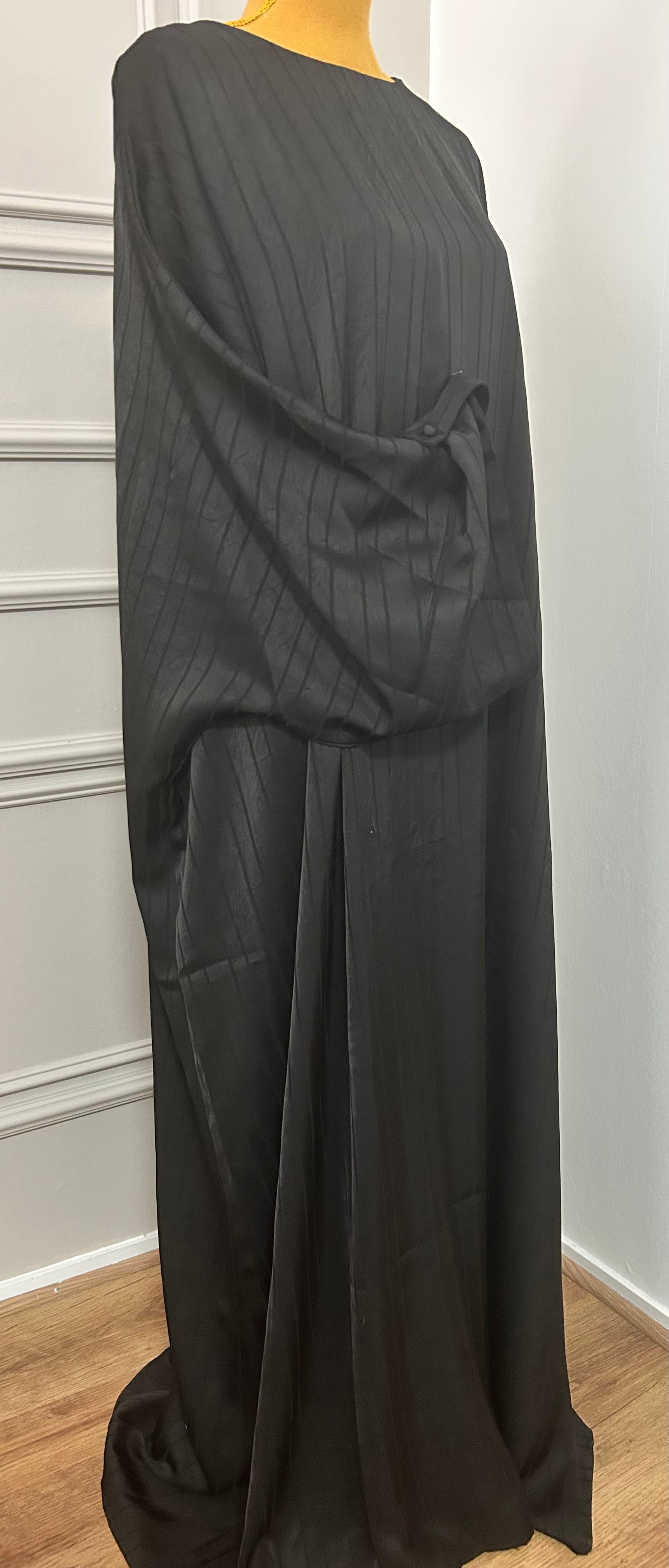 Abaya satinée noir pour femme, coupe longue et fluide, tissu texturé, manches longues, col rond.