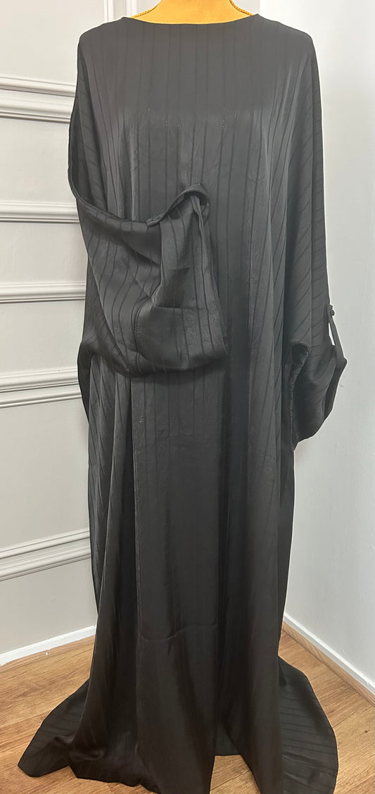 Abaya satinée noir pour femme, coupe longue et fluide, tissu texturé, manches longues, col rond.